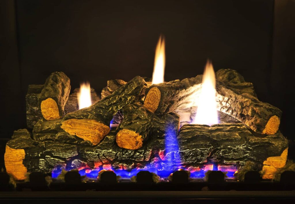 Lit gas fireplace with fake logs